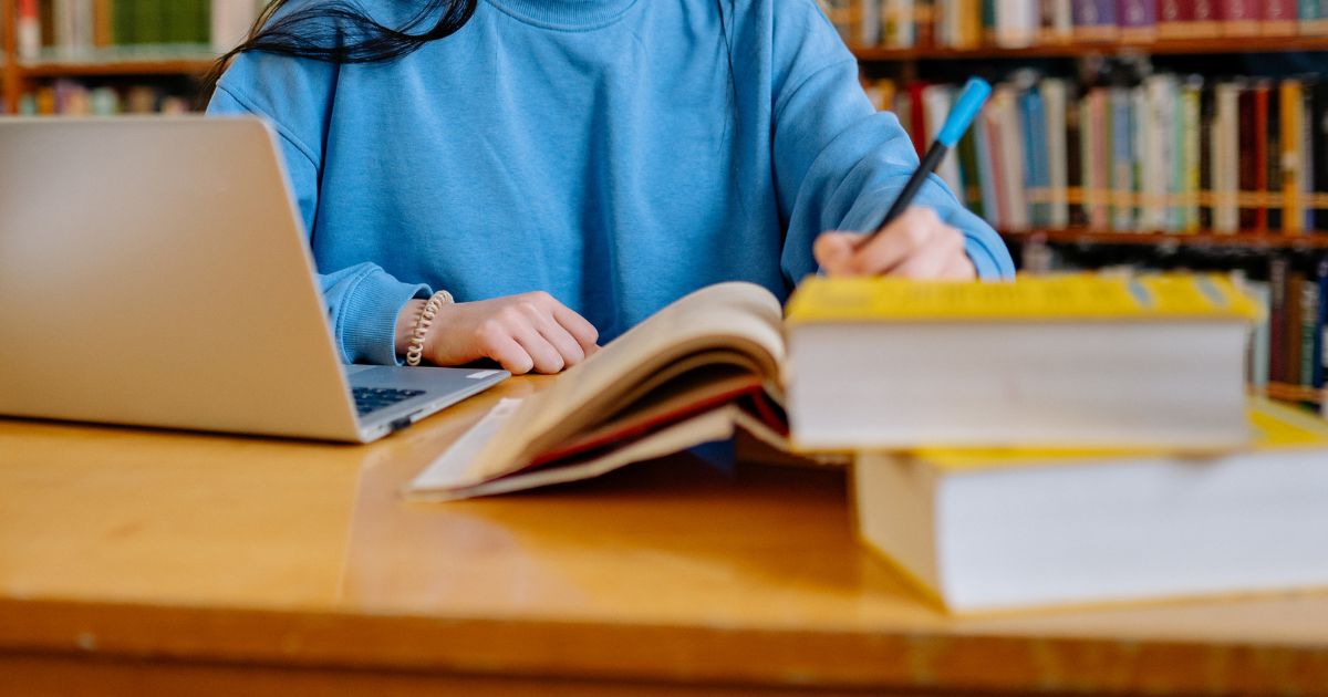 Student studying in a library to save money from buying books